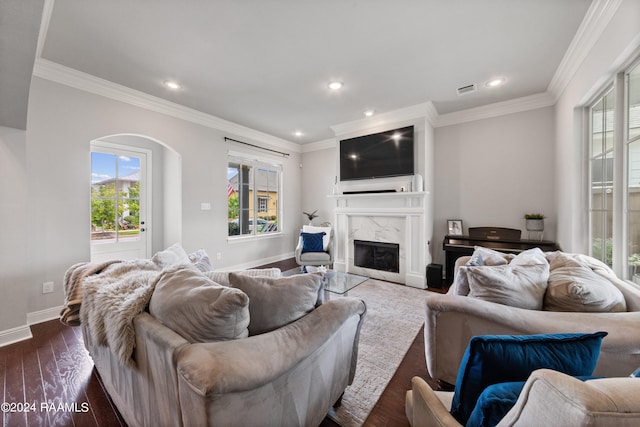 living room with a premium fireplace, crown molding, and dark hardwood / wood-style floors