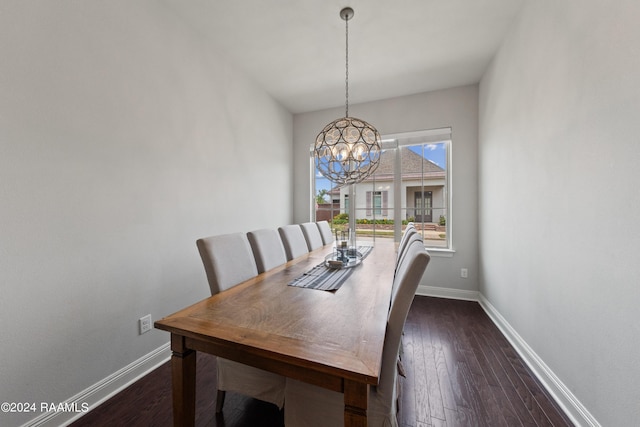 dining room with dark wood-type flooring and a notable chandelier