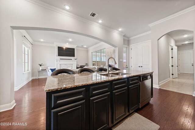 kitchen featuring crown molding, dishwasher, a kitchen island with sink, wood-type flooring, and sink