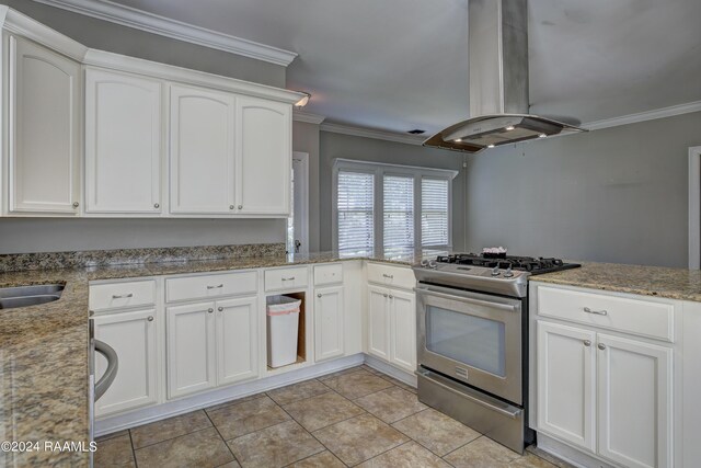 kitchen with crown molding, island range hood, stainless steel range with gas cooktop, and white cabinets