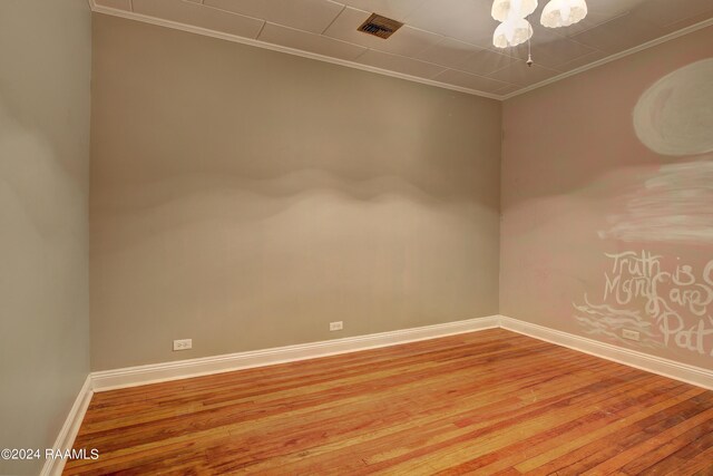 unfurnished room featuring hardwood / wood-style flooring and ornamental molding