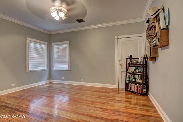 spare room featuring crown molding and light hardwood / wood-style flooring