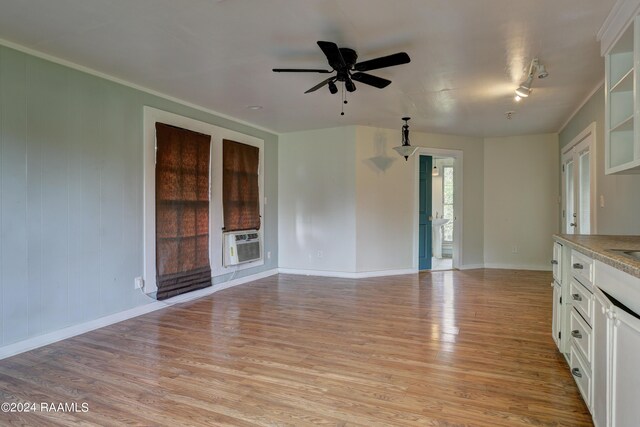 interior space featuring cooling unit, ceiling fan, ornamental molding, and light wood-type flooring