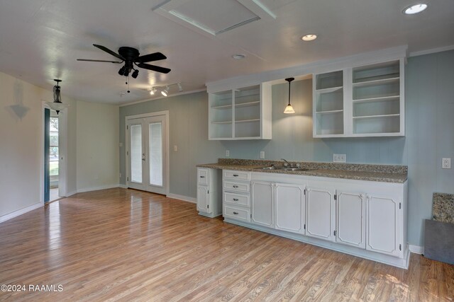 kitchen with white cabinetry, sink, hanging light fixtures, light wood-type flooring, and french doors