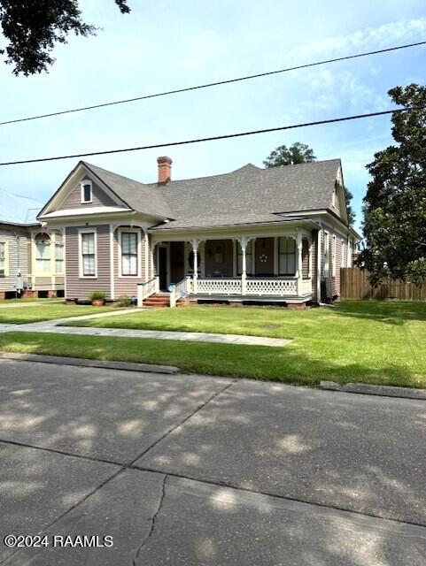 view of front of home with a porch and a front lawn