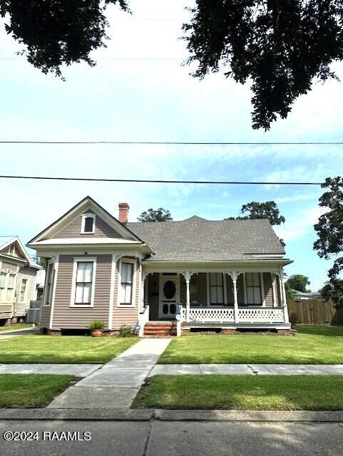 view of front facade with a front lawn and covered porch