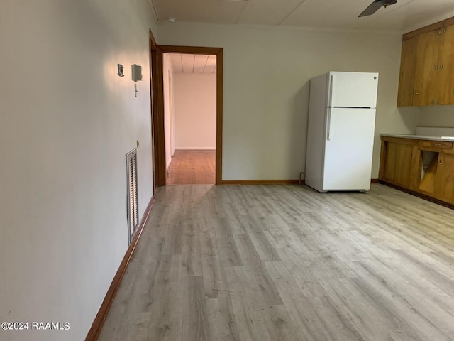 kitchen with light wood-type flooring, ceiling fan, and white refrigerator