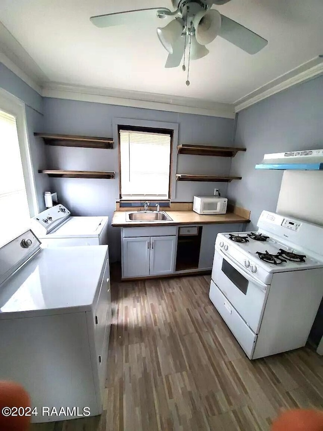 kitchen with washing machine and clothes dryer, sink, ornamental molding, dark hardwood / wood-style flooring, and white appliances