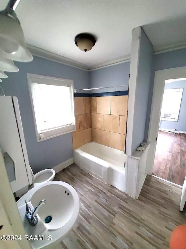 bathroom with wood-type flooring, a healthy amount of sunlight, bathtub / shower combination, and crown molding