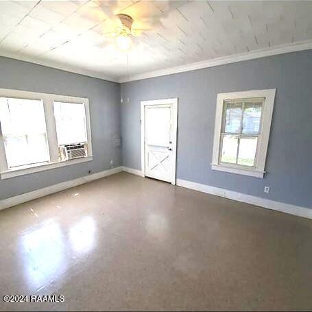 unfurnished room with crown molding, cooling unit, concrete floors, and ceiling fan