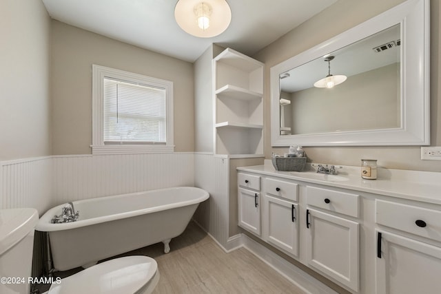 bathroom with vanity, hardwood / wood-style floors, a bathtub, and toilet