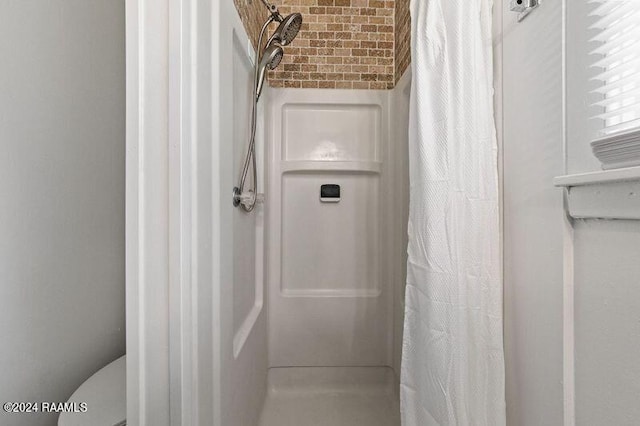 bathroom featuring a shower with curtain and brick ceiling