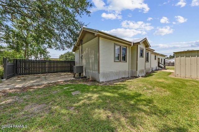 view of side of property featuring a lawn and a patio