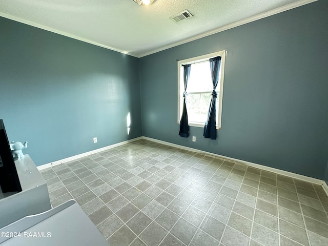 unfurnished room featuring ornamental molding and a textured ceiling