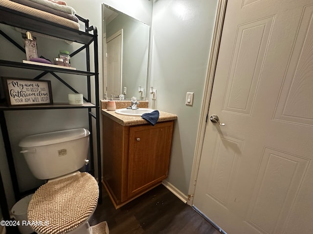 bathroom with vanity, toilet, and wood-type flooring