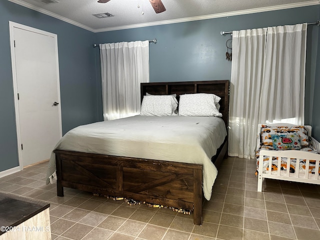 tiled bedroom with ceiling fan, a textured ceiling, and ornamental molding