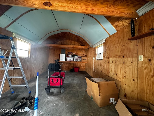 miscellaneous room with vaulted ceiling, cooling unit, and wood walls