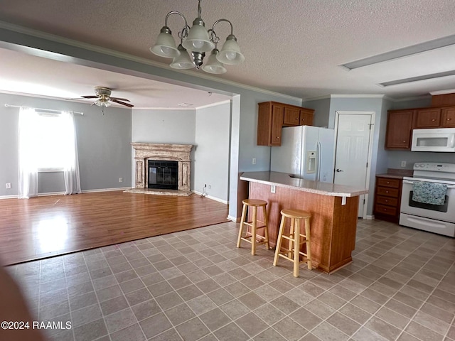 kitchen featuring a kitchen bar, light hardwood / wood-style flooring, ceiling fan with notable chandelier, crown molding, and white appliances