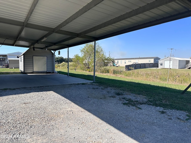 view of parking / parking lot featuring a lawn and a carport