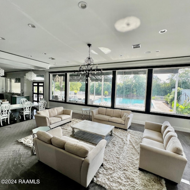 carpeted living room featuring a chandelier and plenty of natural light