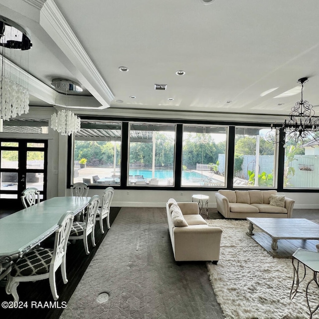 living room with ornamental molding, an inviting chandelier, and french doors