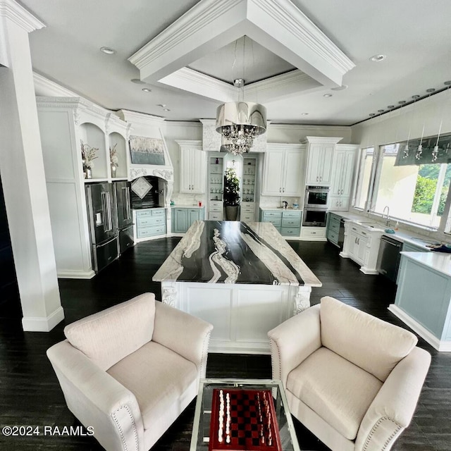 interior space featuring dark wood-style floors, a notable chandelier, white cabinetry, a kitchen island, and high end refrigerator