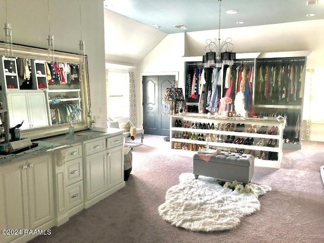 interior space featuring lofted ceiling, an inviting chandelier, and carpet flooring