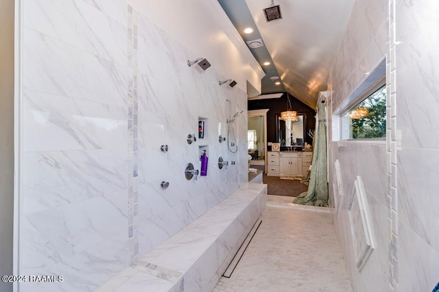 bathroom with lofted ceiling, vanity, and tile walls