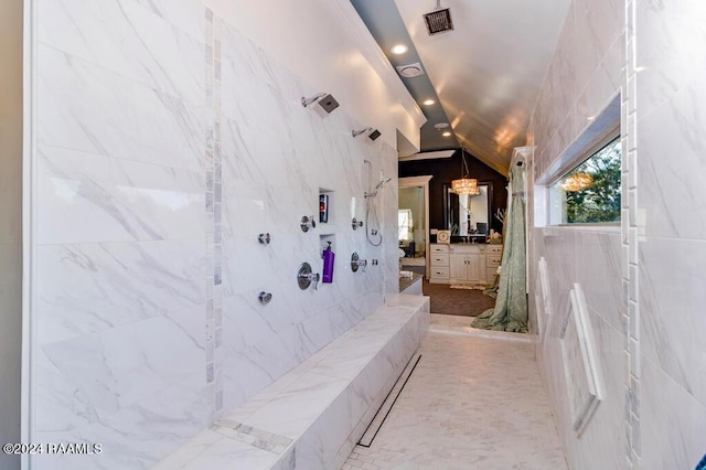 full bath with recessed lighting, visible vents, vanity, vaulted ceiling, and a marble finish shower