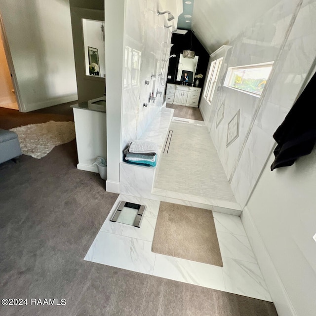 bathroom featuring tile patterned flooring and vaulted ceiling