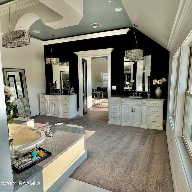 full bath featuring lofted ceiling, ornamental molding, two vanities, and a sink