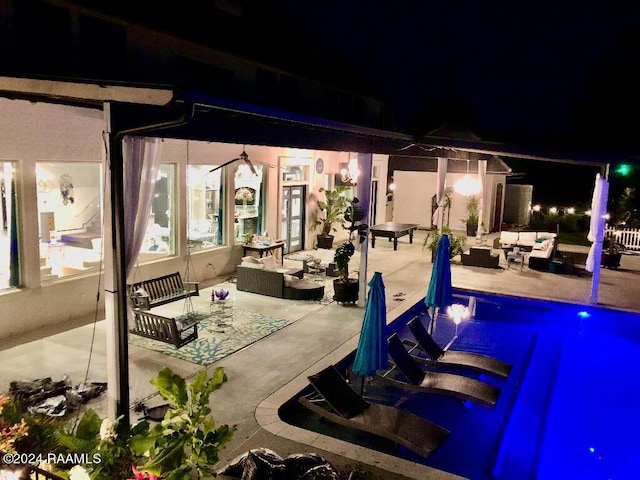 patio at night featuring an outdoor hangout area