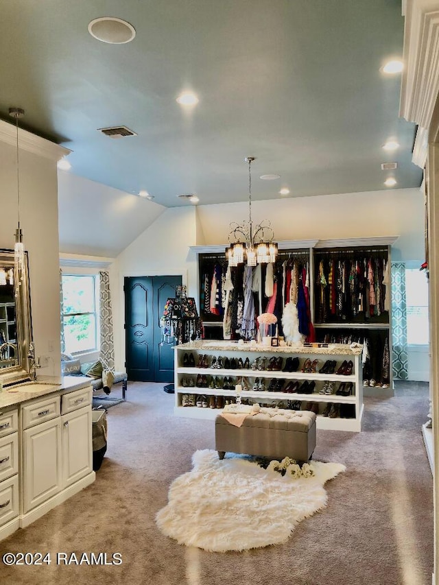 walk in closet featuring light carpet, visible vents, a chandelier, and lofted ceiling