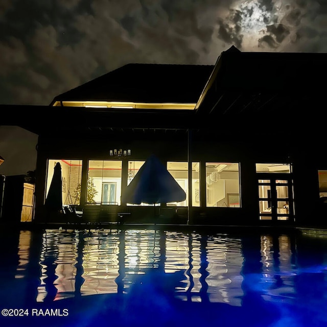 view of pool at twilight