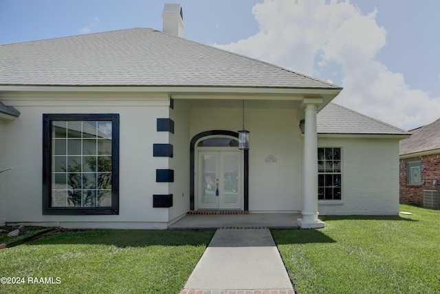 property entrance with a yard and cooling unit