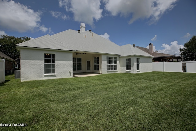 back of house featuring central AC unit, a patio, and a yard