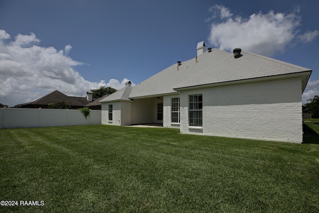 rear view of property featuring a lawn