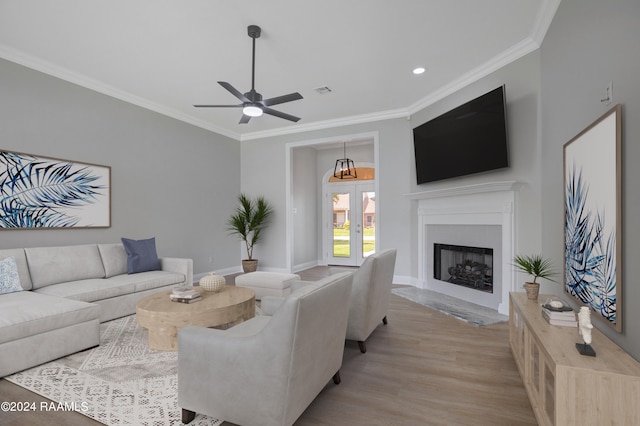 living room with light hardwood / wood-style flooring, ceiling fan, and crown molding