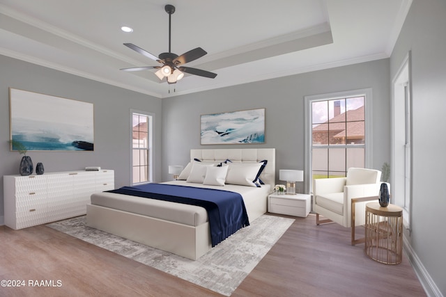 bedroom featuring ceiling fan, wood-type flooring, ornamental molding, and a raised ceiling