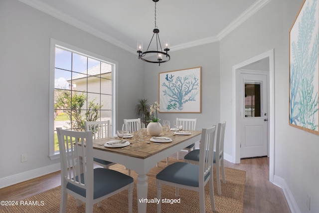 dining room with an inviting chandelier, wood-type flooring, and ornamental molding