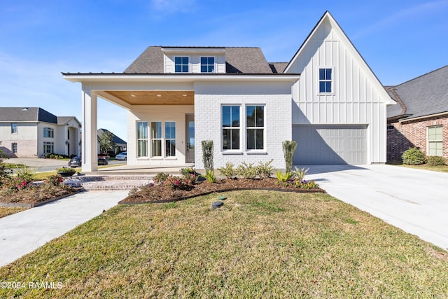 view of front of house featuring a garage, covered porch, and a front lawn