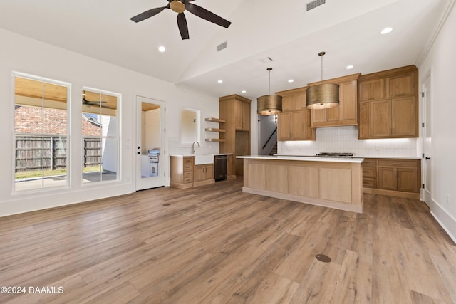 kitchen featuring vaulted ceiling, a kitchen island, pendant lighting, tasteful backsplash, and light wood-type flooring