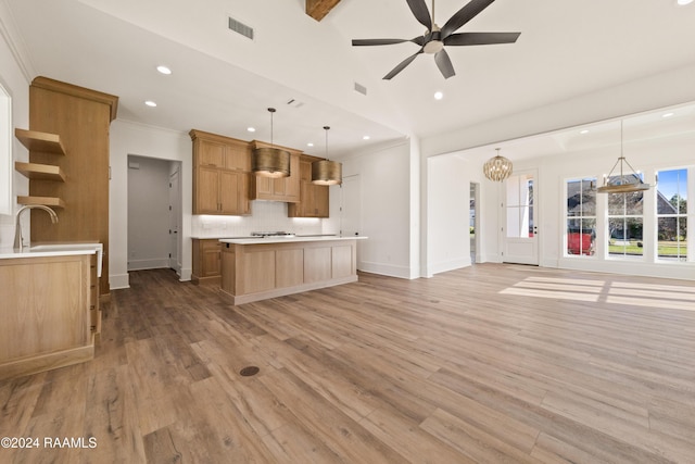 kitchen with ceiling fan, hanging light fixtures, tasteful backsplash, a kitchen island, and light wood-type flooring