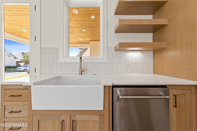 kitchen with sink, stainless steel dishwasher, backsplash, and light brown cabinetry