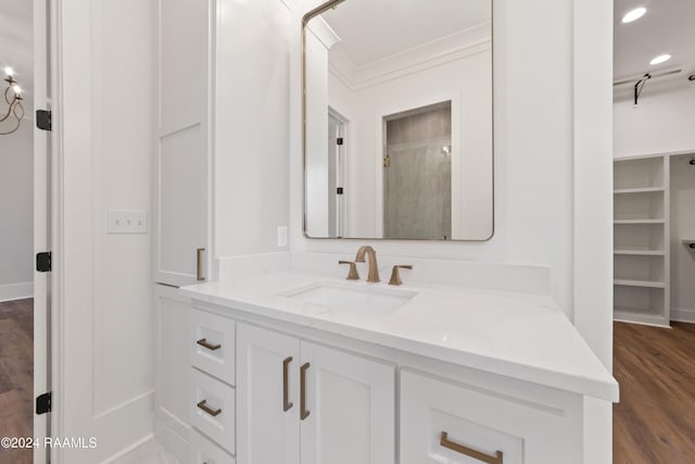 bathroom featuring wood-type flooring, vanity, and crown molding