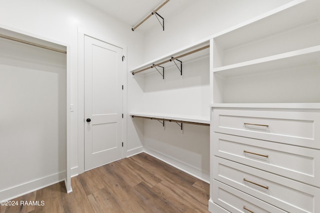 walk in closet with dark hardwood / wood-style flooring