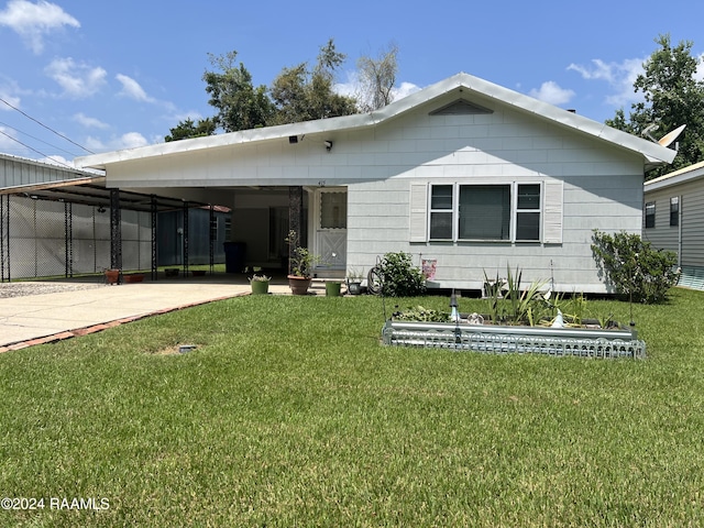 back of house with a lawn and a carport