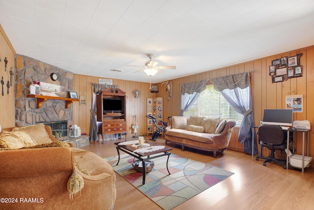 living room with ceiling fan, a fireplace, and light hardwood / wood-style flooring