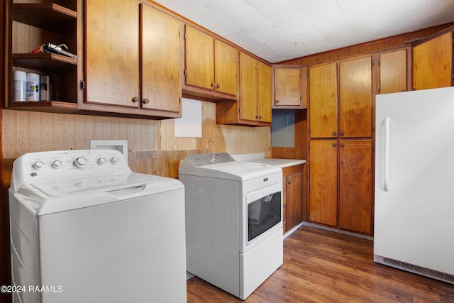 clothes washing area featuring cabinets, separate washer and dryer, and dark wood-type flooring