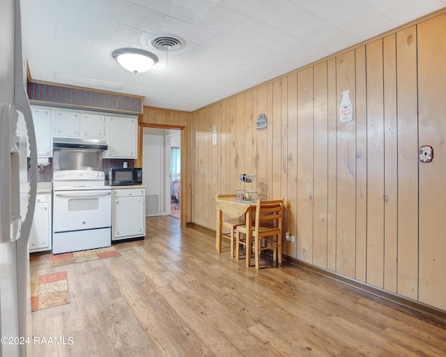 kitchen featuring white cabinets, wooden walls, electric range, and light hardwood / wood-style floors